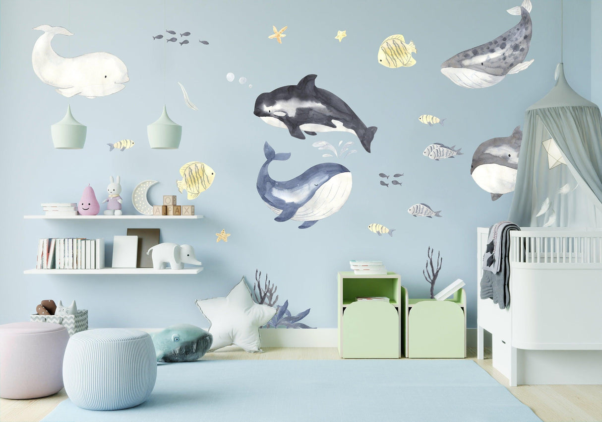 Colorful ocean-themed wall stickers featuring whales and marine life in a child's bedroom decor.