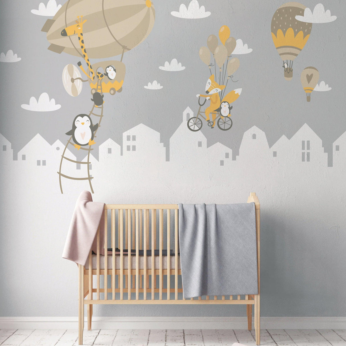 WhimsyLand wall decals featuring penguins, foxes, and hot air balloons above a crib, creating a playful nursery atmosphere.