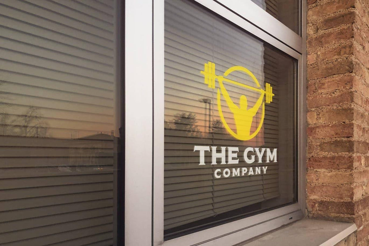 Custom vinyl sticker on gym window displaying logo and weights, perfect for branding and personalization.