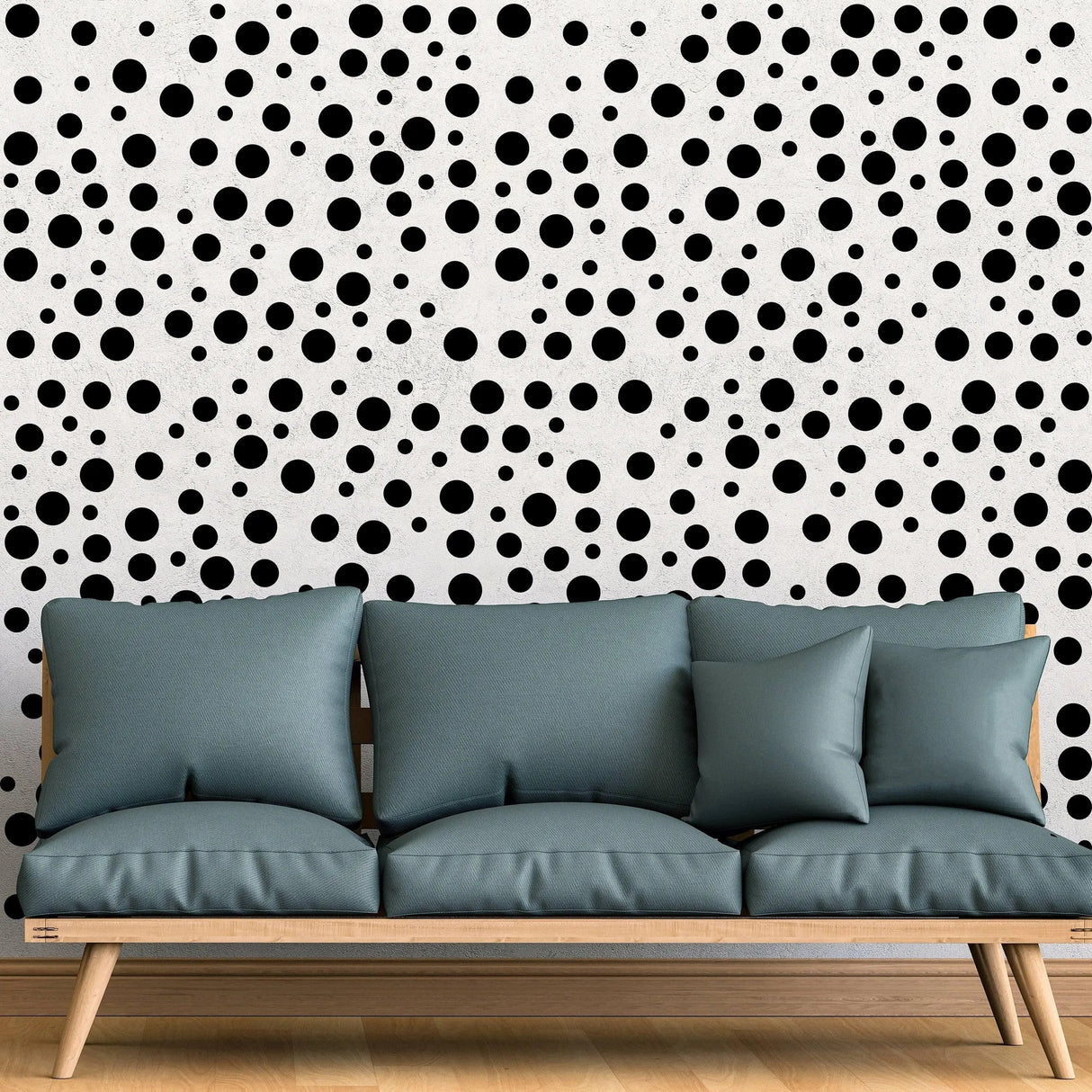 Black polka dot wall decals on white wall behind a teal sofa, adding a playful touch to interior decoration.