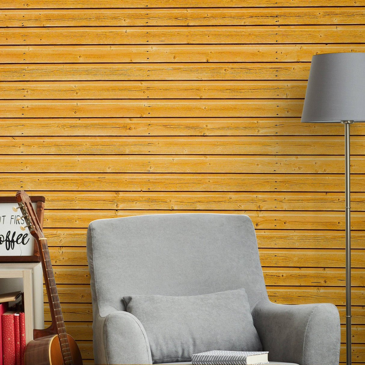 Rustic wood plank peel and stick wallpaper in a cozy living room setting with gray armchair and lamp.