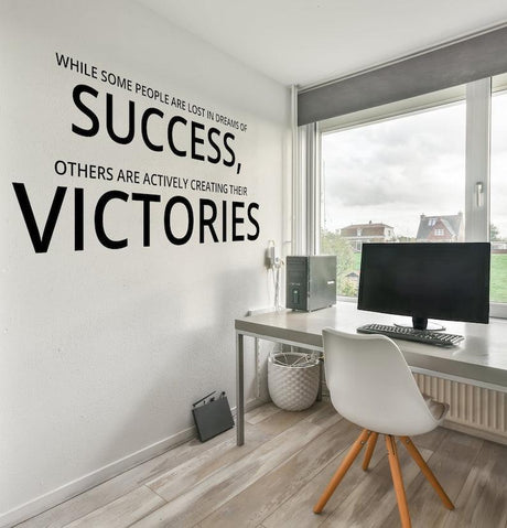 Motivational wall decal in home office with quote about success and victories on a white wall.