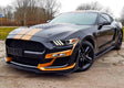 Stylish race-inspired black car with vibrant orange racing stripes showcasing stunning vehicle customization.