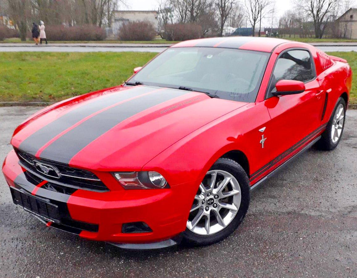 Red Mustang with stylish black racing stripes showcasing a vibrant car makeover.