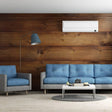 Modern living room featuring wooden wall, blue sofas, and stylish lamp, showcasing wooden effect vinyl decals.