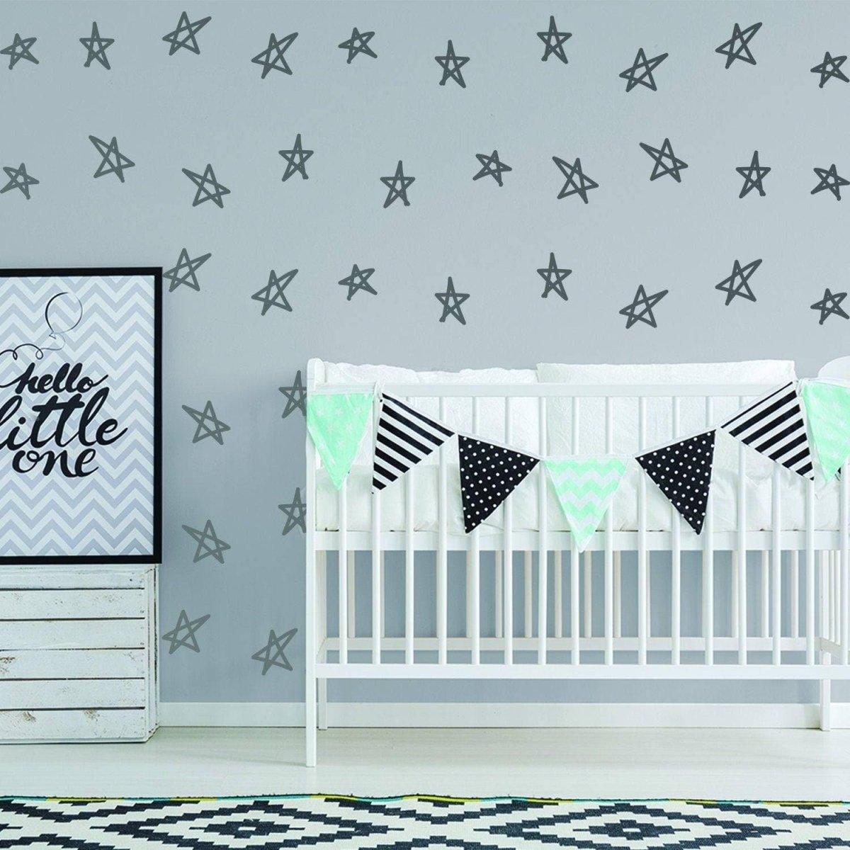 Nursery decor featuring magical star stickers on the wall and a crib with festive bunting for a baby shower.