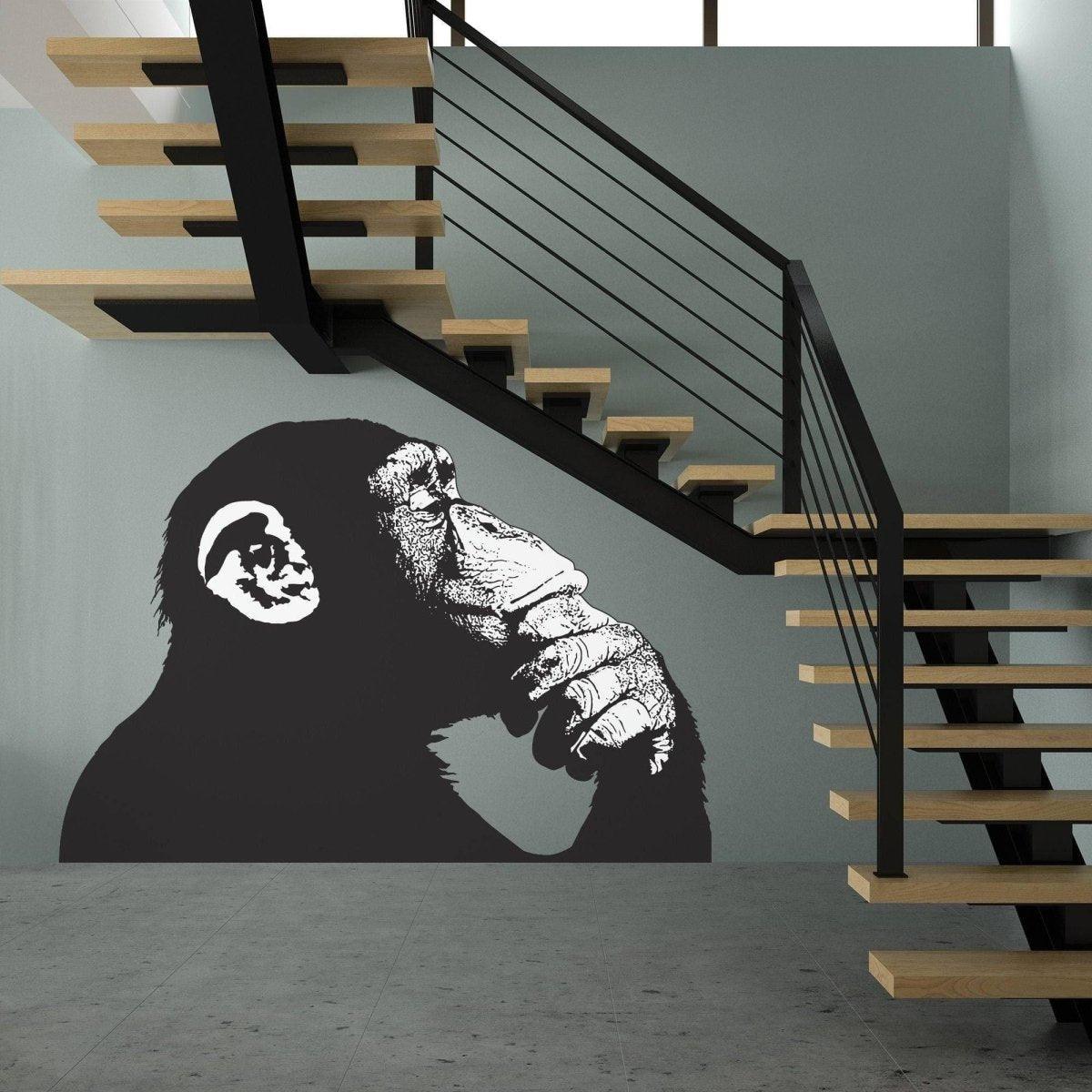 Artistic wall decal of a thoughtful monkey in a modern stairwell, showcasing contemporary street art style.