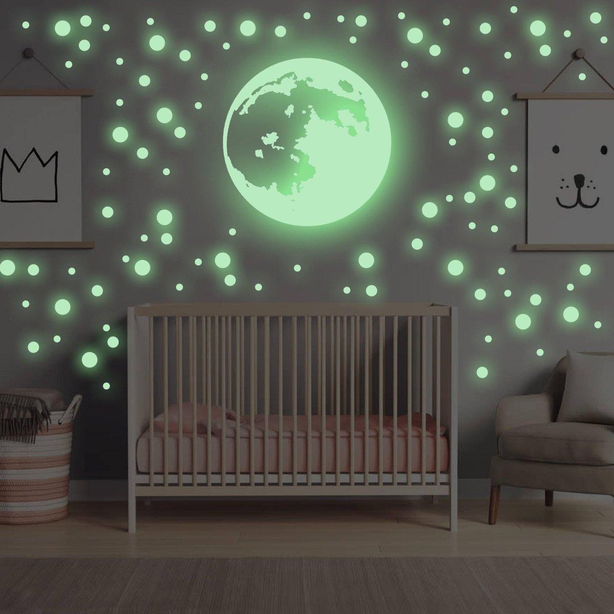 Glow in the dark moon and star wall stickers illuminating a nursery, creating a magical celestial theme.