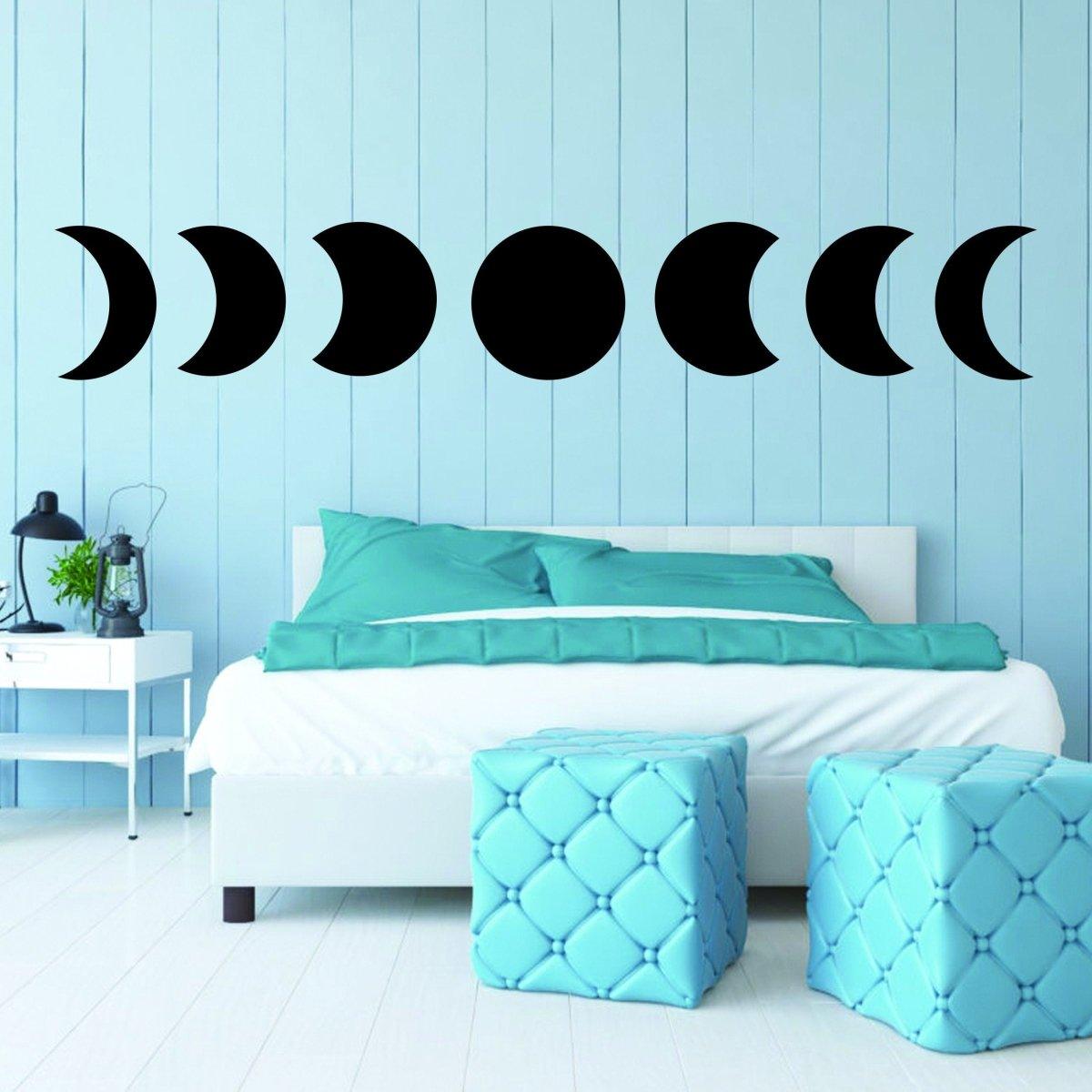 Moon Phase Wall Hanging Decor above a bed; black designs on light blue wall for celestial home decor.
