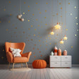 Cozy room with orange chair, star wall decals, and pendant lights, showcasing Gold Stars Vinyl Wall Stickers.