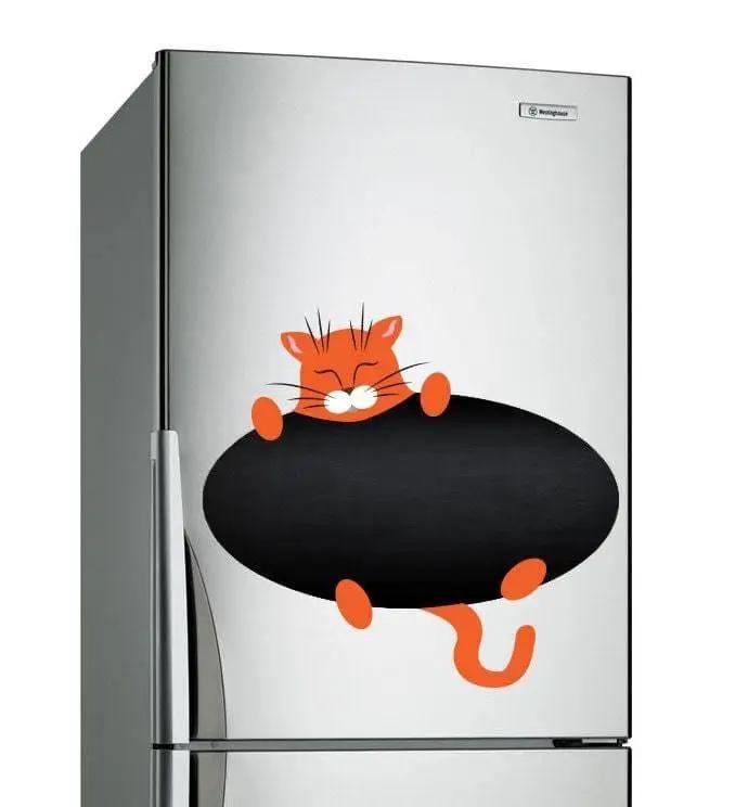 Magnetic chalkboard sticker of a cute orange cat on a silver refrigerator, adding creativity to kitchen decor.