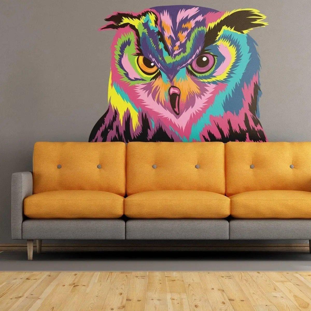Colorful owl wall sticker above a gray couch, adding charm and vibrancy to home decor.