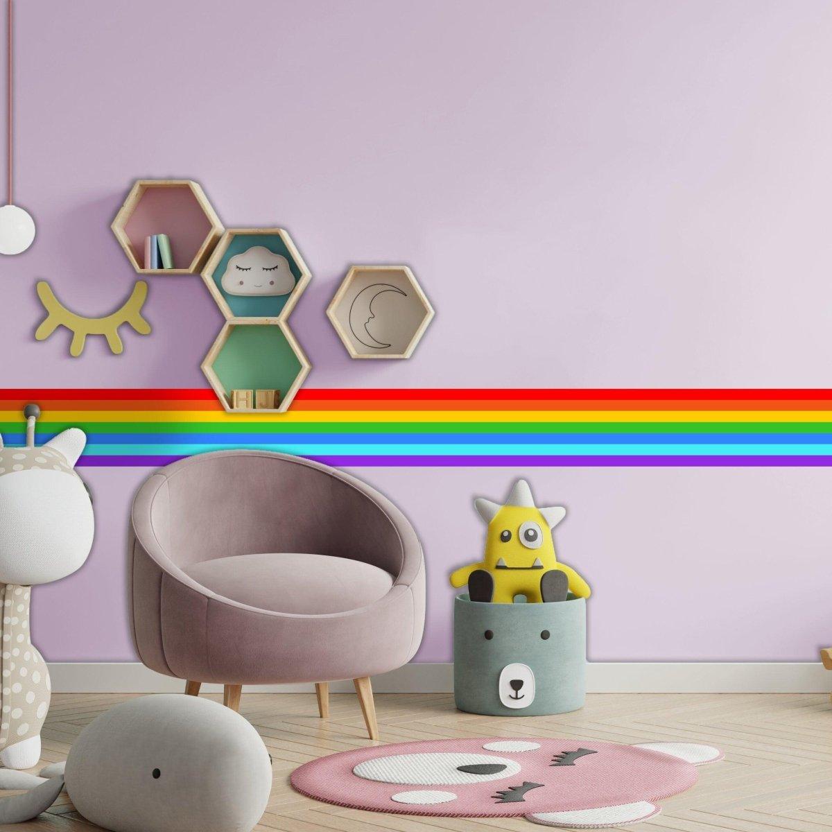 Colorful rainbow adhesive wall decal in a modern nursery with cozy seating and playful decorations.