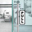 Clear 'PULL' sticker on stylish glass door handle in modern living space.
