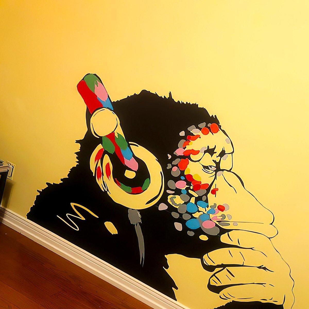 Contemplative monkey wall decal with colorful headphones on yellow wall, perfect for kids' room decor.
