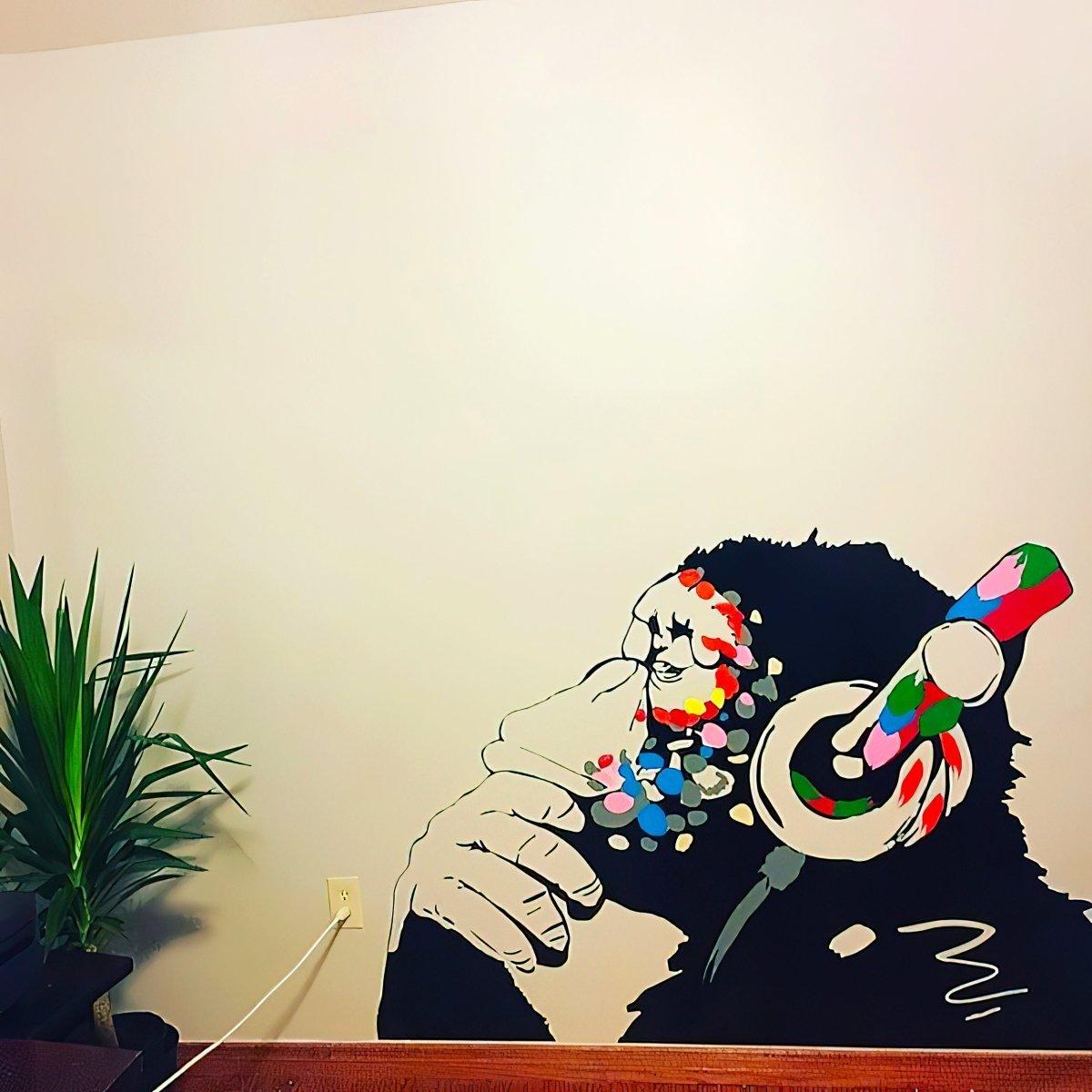 Contemplative monkey wall decal with headphones, perfect for kids room decoration and adding personality.