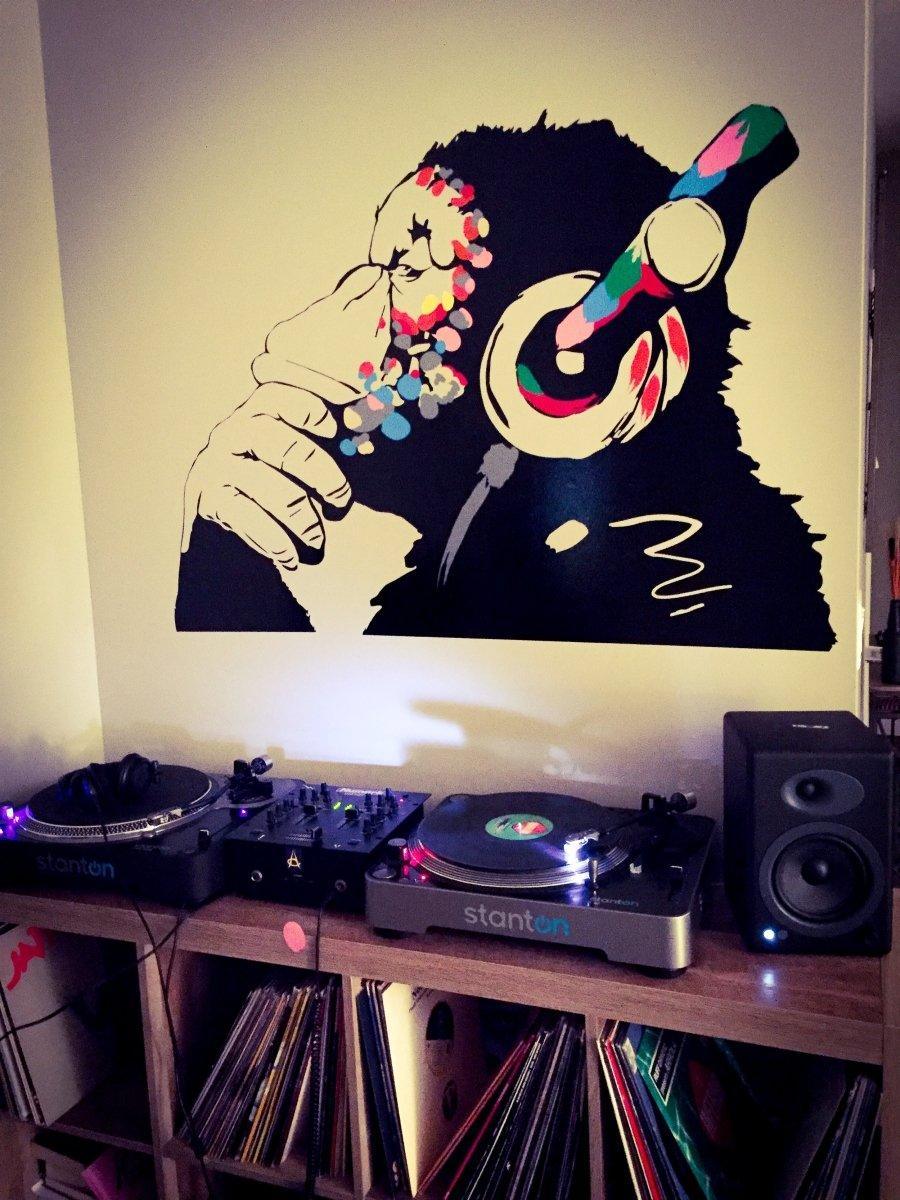 Cool monkey wall decal with headphones above DJ turntables, adding personality to a music-themed kids room.