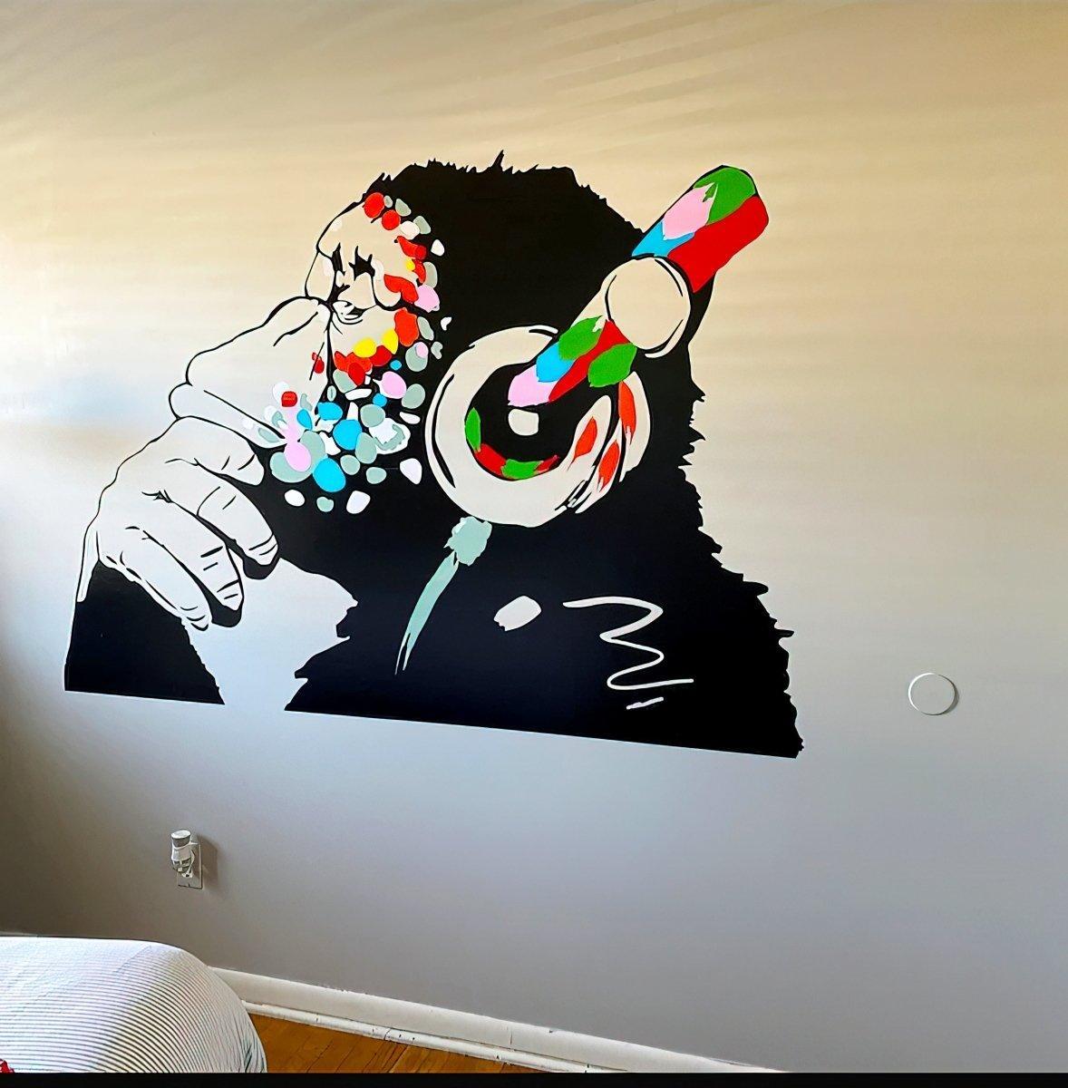 Colorful monkey wall decal with headphones, ideal for kids' rooms and music enthusiasts. Unique and playful wall decoration.