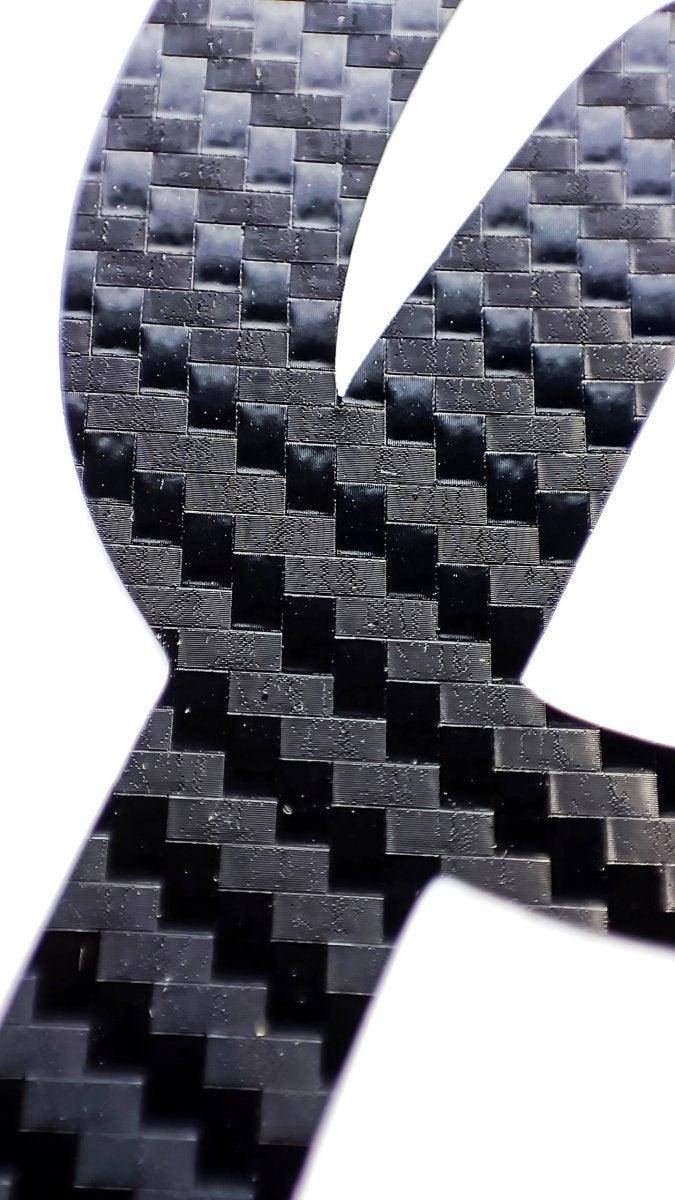 Close-up of personalized carbon fiber letter sticker showcasing its durable and stylish texture.