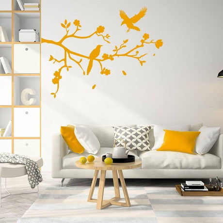 Chic yellow tree branch wall decal with birds in a modern living room with stylish decor and a cozy couch.