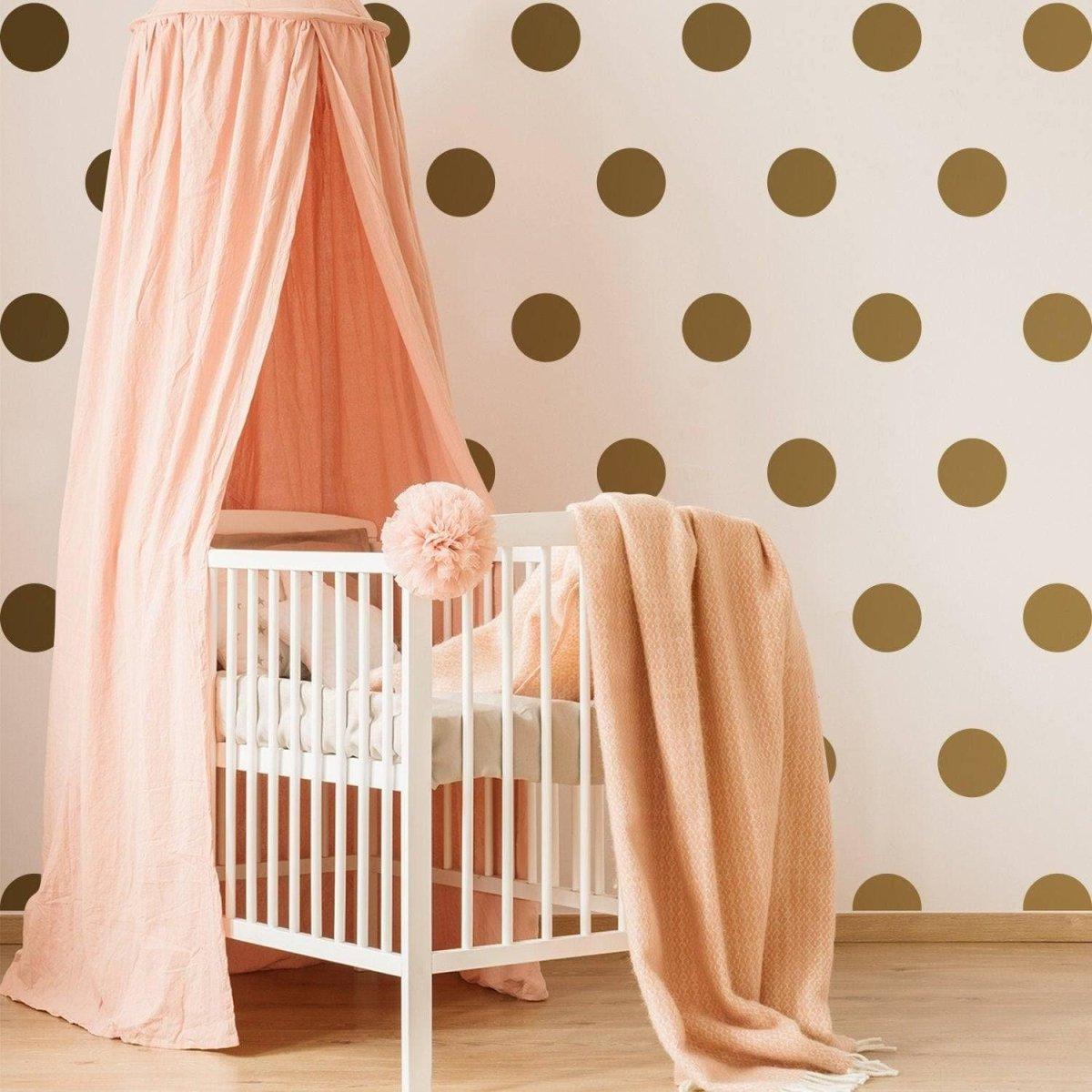 Chic gold circle wall stickers enhance a nursery with elegance, complementing a pink crib and soft textures.