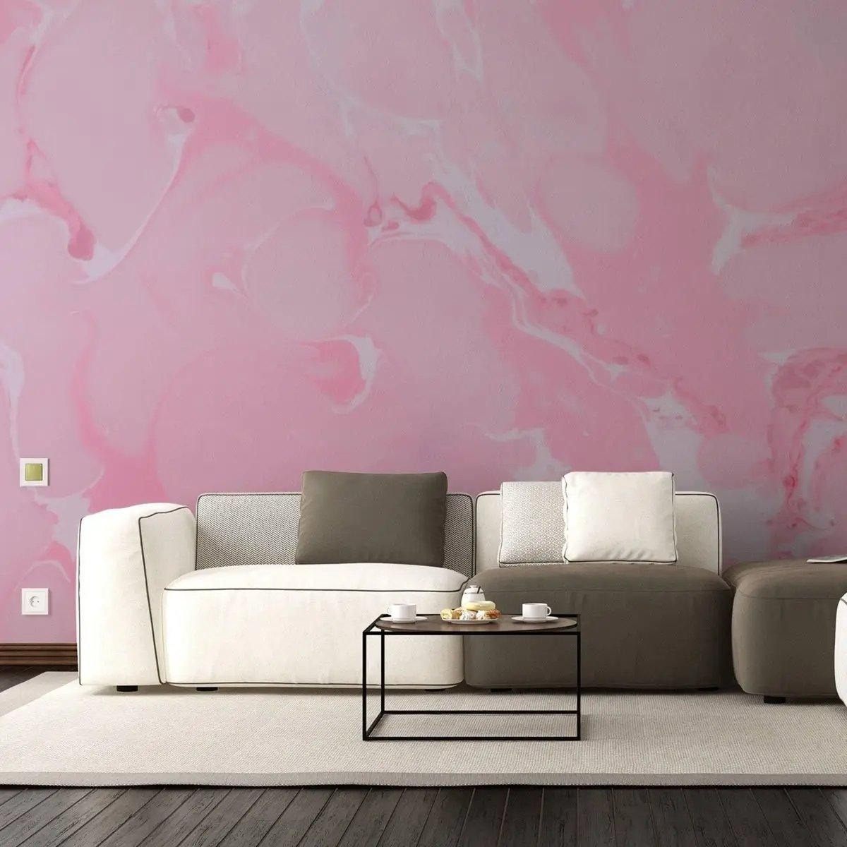 Elegant pink marble wallpaper accent wall behind modern furniture and coffee table in a cozy living room setting.