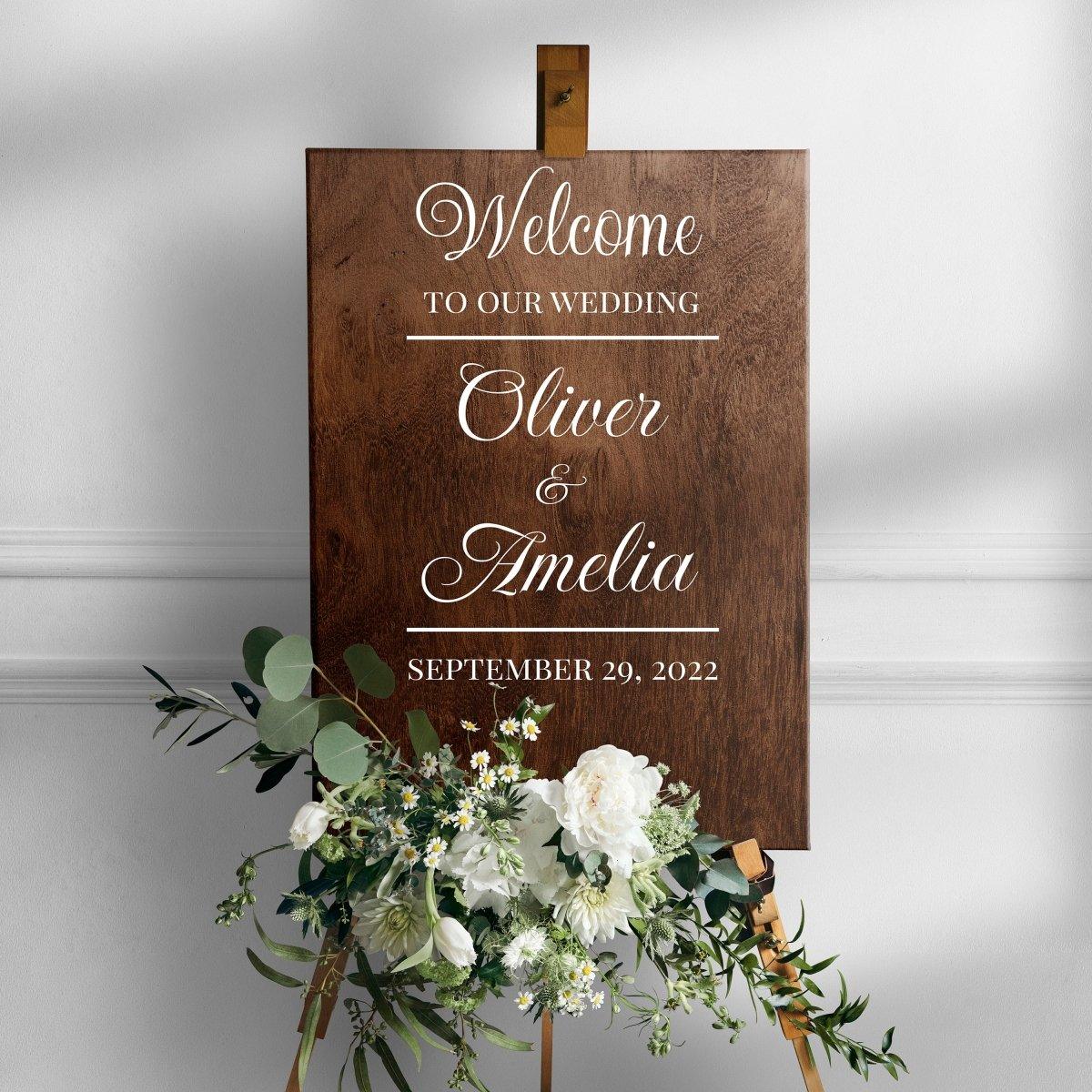 Personalized wedding welcome sign decal featuring names Oliver & Amelia, dated September 29, 2022, with floral arrangement.
