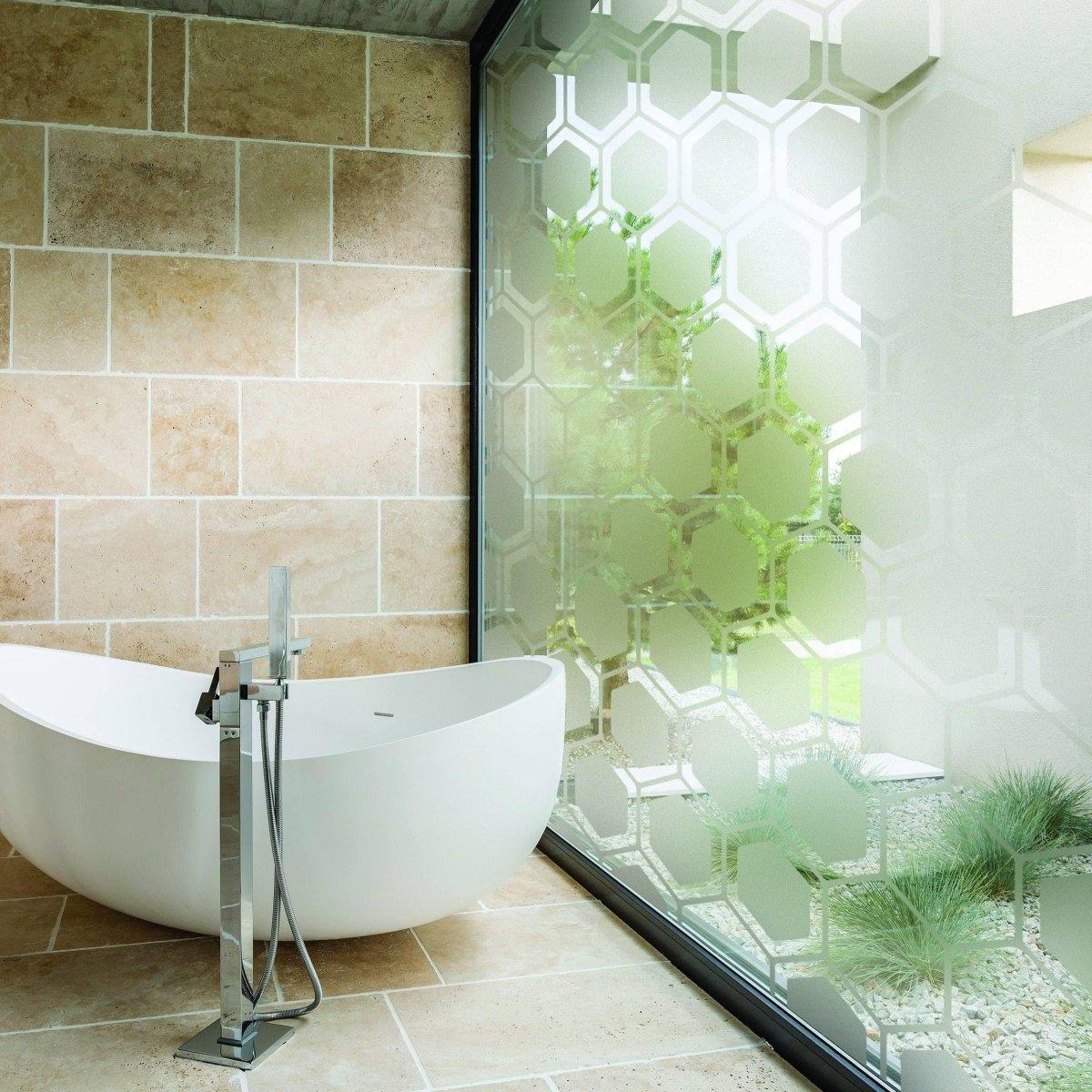 Stylish frosted glass film on bathroom window providing privacy and aesthetic appeal, with modern bathtub design.