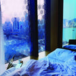 Stylish frosted window film in a modern bedroom, enhancing privacy and light while showcasing a city view.