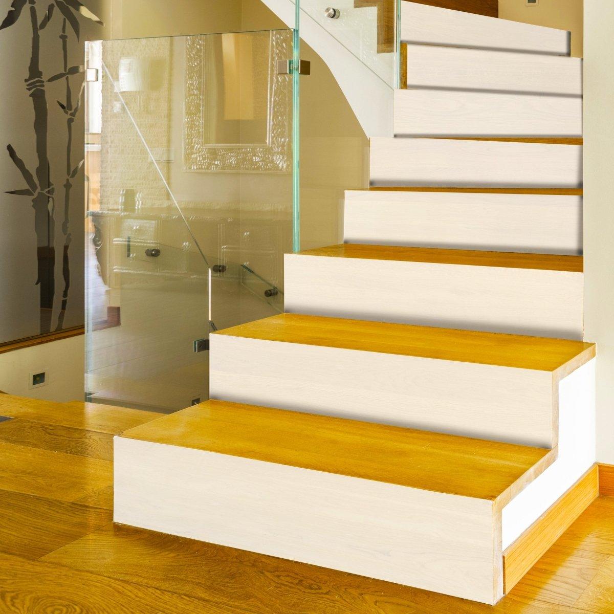 Stunning staircase transformed with white self-adhesive risers and wooden treads, showcasing elegant home decor.