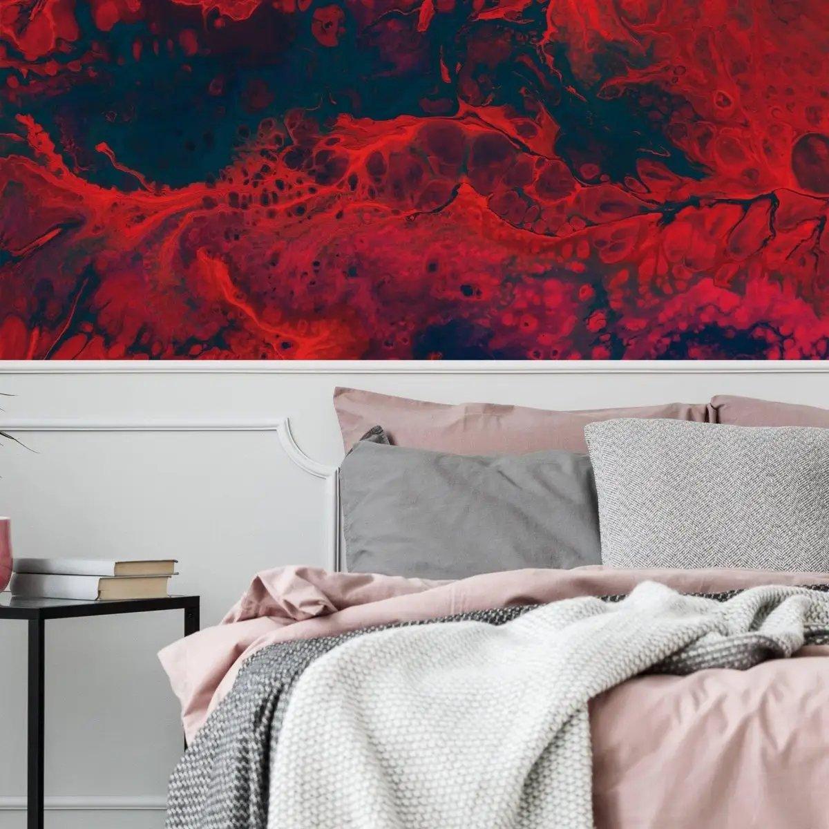 Vibrant red and blue abstract wallpaper above a cozy bed with gray and pink bedding, enhancing room decor.