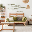 Vinyl wall sticker with Walt Disney quote in a cozy living room setting, featuring lush green pillows and natural decor.