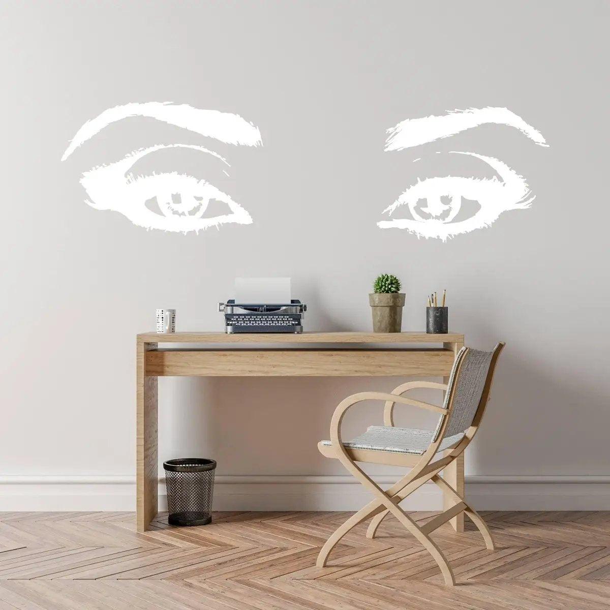 Glowing luminescent eye wall decals above a wooden desk in a stylish workspace.