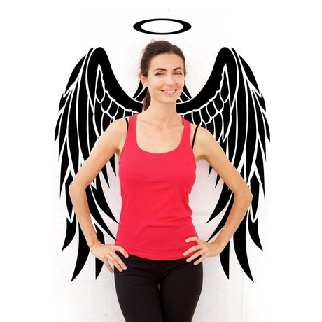 Woman posing in front of angel wings wall decal, wearing a red tank top, showcasing ethereal wall art.