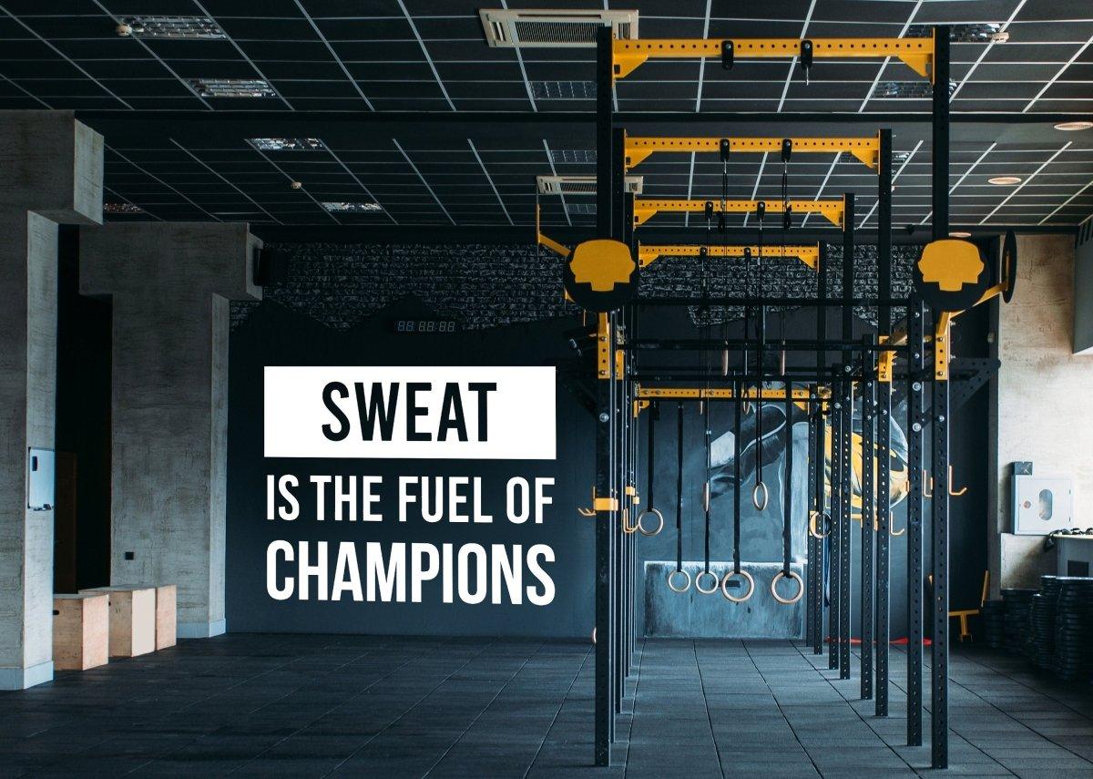 Inspiring gym wall with text: 'Sweat is the fuel of champions', ideal for motivation and workout inspiration.