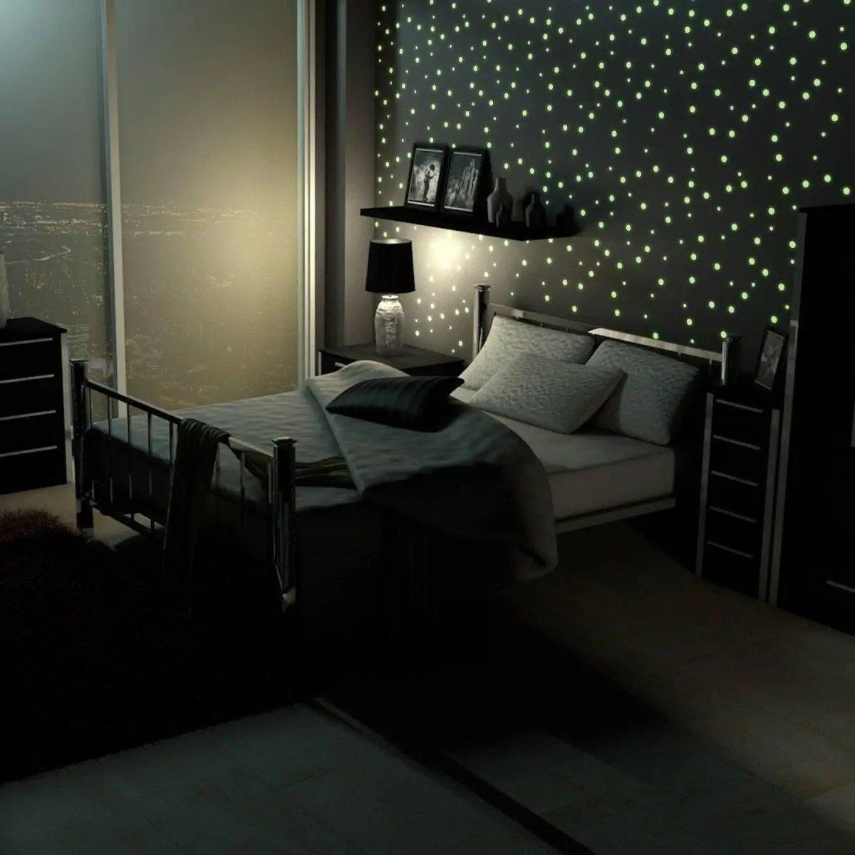 Cozy bedroom with luminous cosmic circle wall decals creating a starry night sky effect.