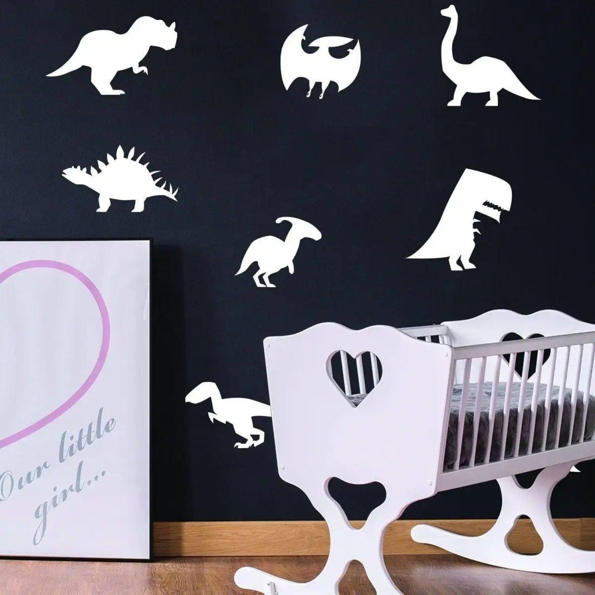 Glow-in-the-dark dinosaur wall decals in a nursery, featuring various dinosaur silhouettes on a black wall.