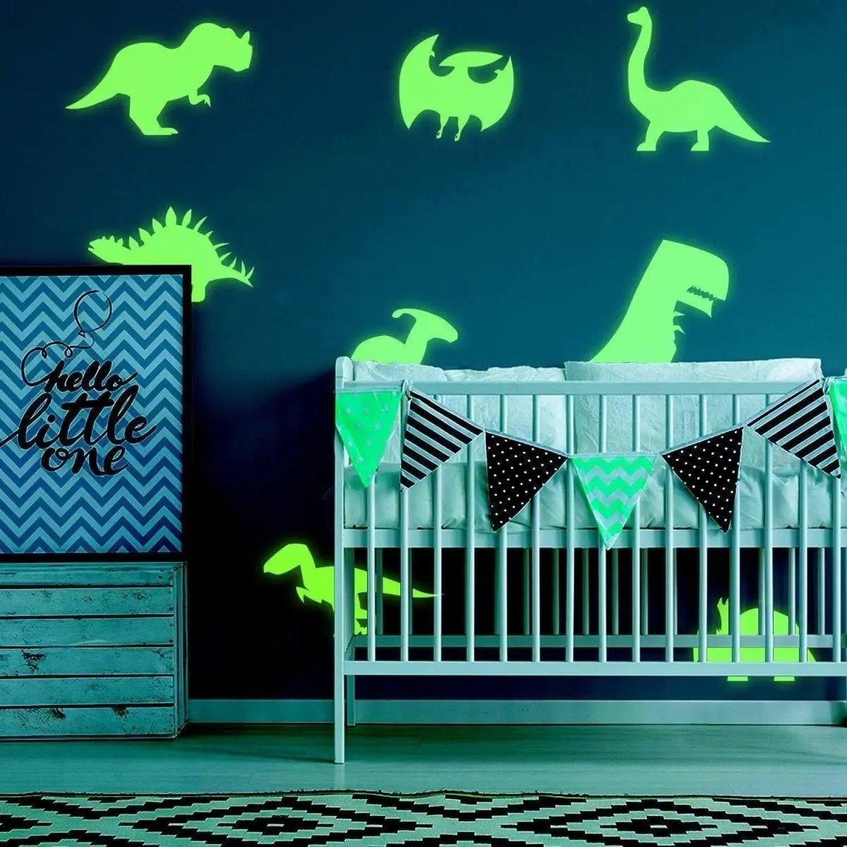 Glow-in-the-dark dinosaur wall decals in a stylish nursery with crib and decorative banners.