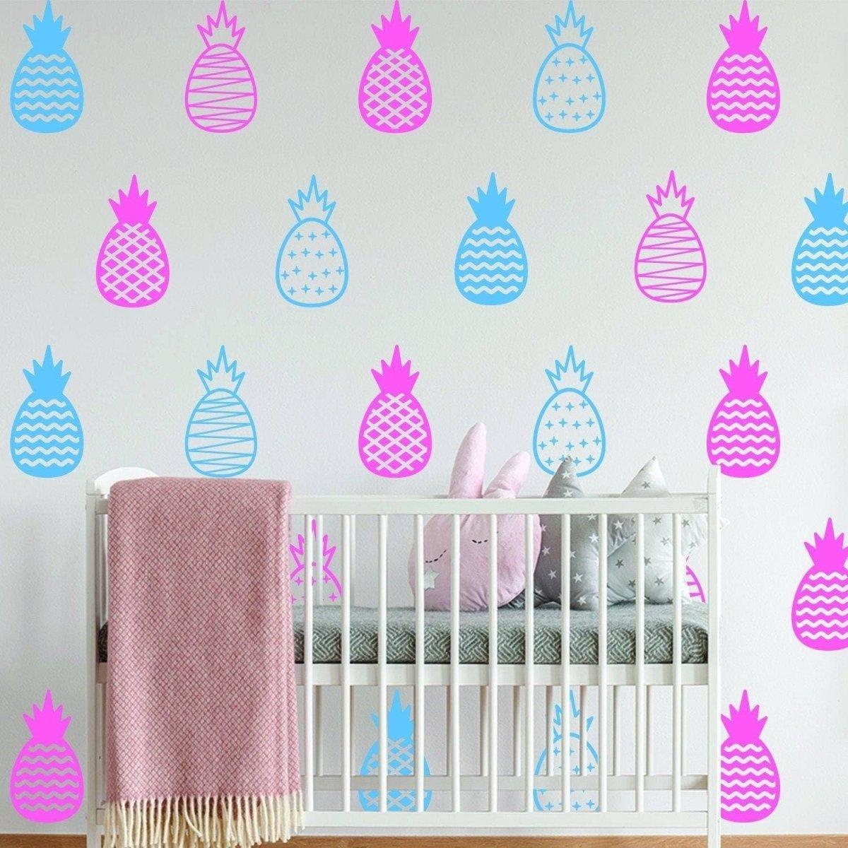 Chic vinyl pineapple wall decals in pink and blue, adding a whimsical touch to a nursery or playful space.