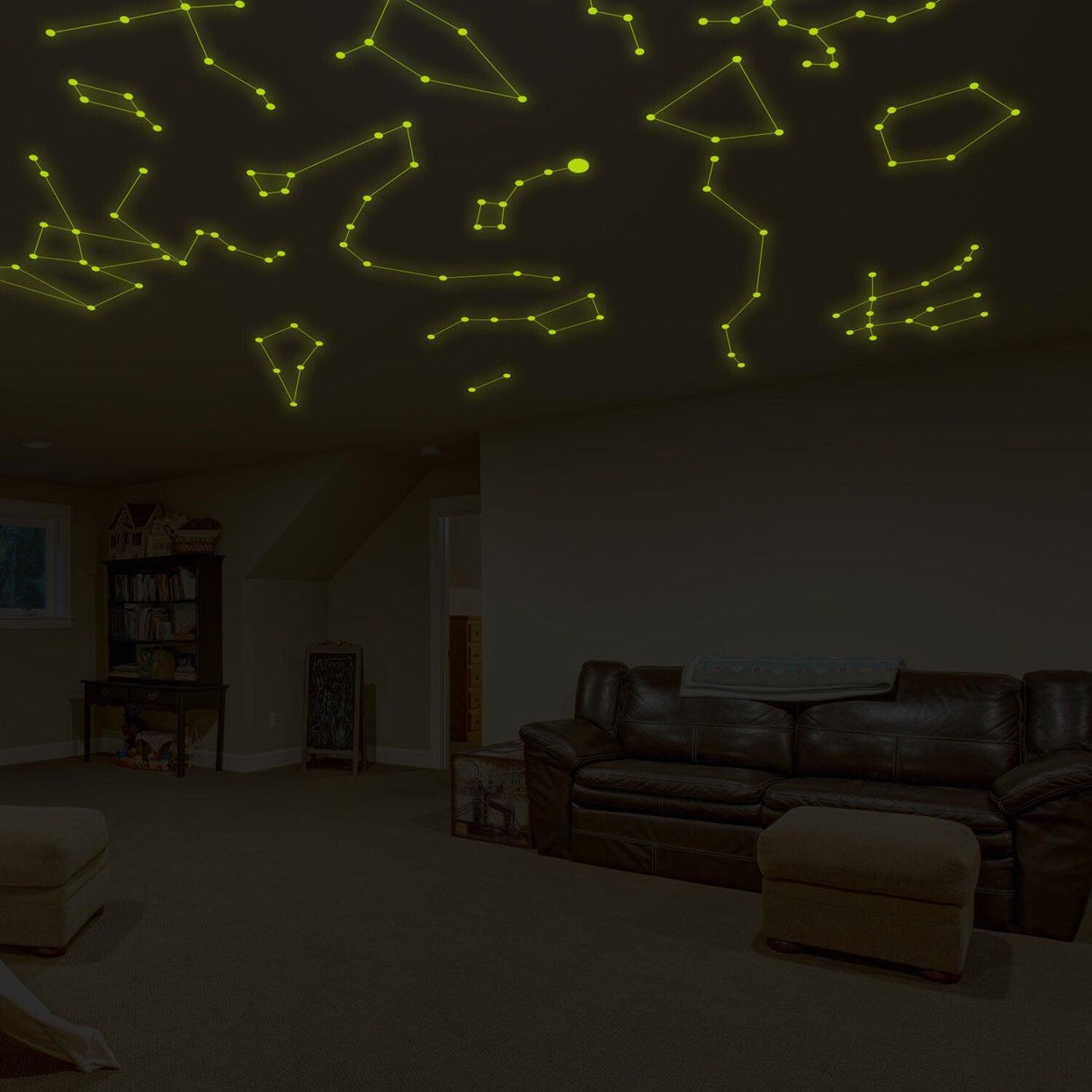Glowing vinyl wall decals of constellations on a dark ceiling in a cozy living room.