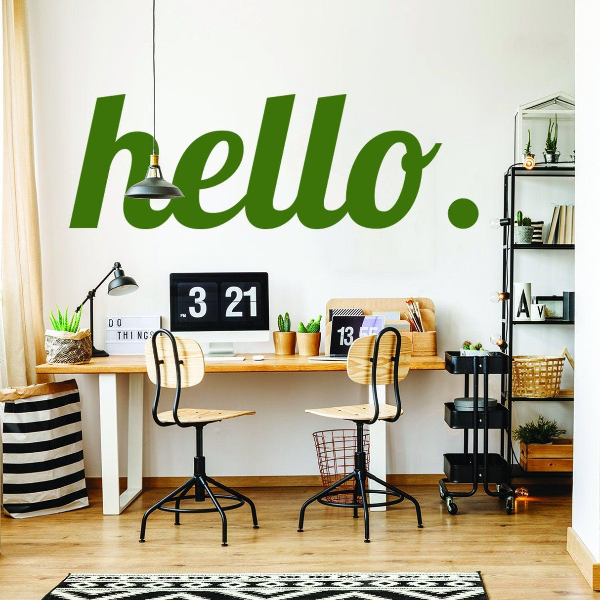 Hello vinyl sticker in green on a wall above a stylish workspace with desk and chairs.