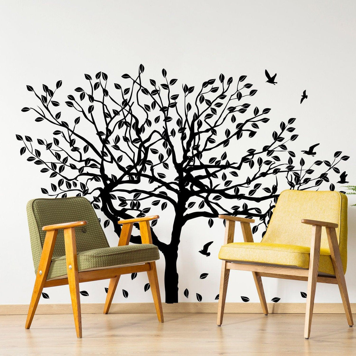 Black tree wall decal with birds and leaves in a cozy living space with modern chairs.