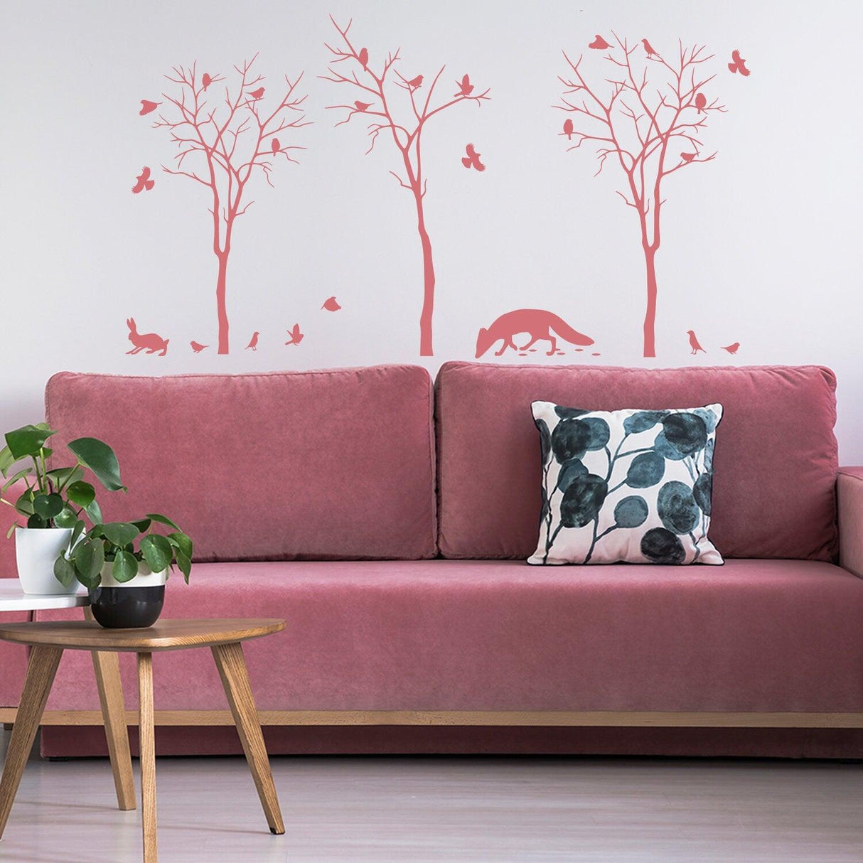 Nature Art Vinyl Cute Animal Set Stickers with trees, animals, and butterflies above a pink couch in a cozy living room.