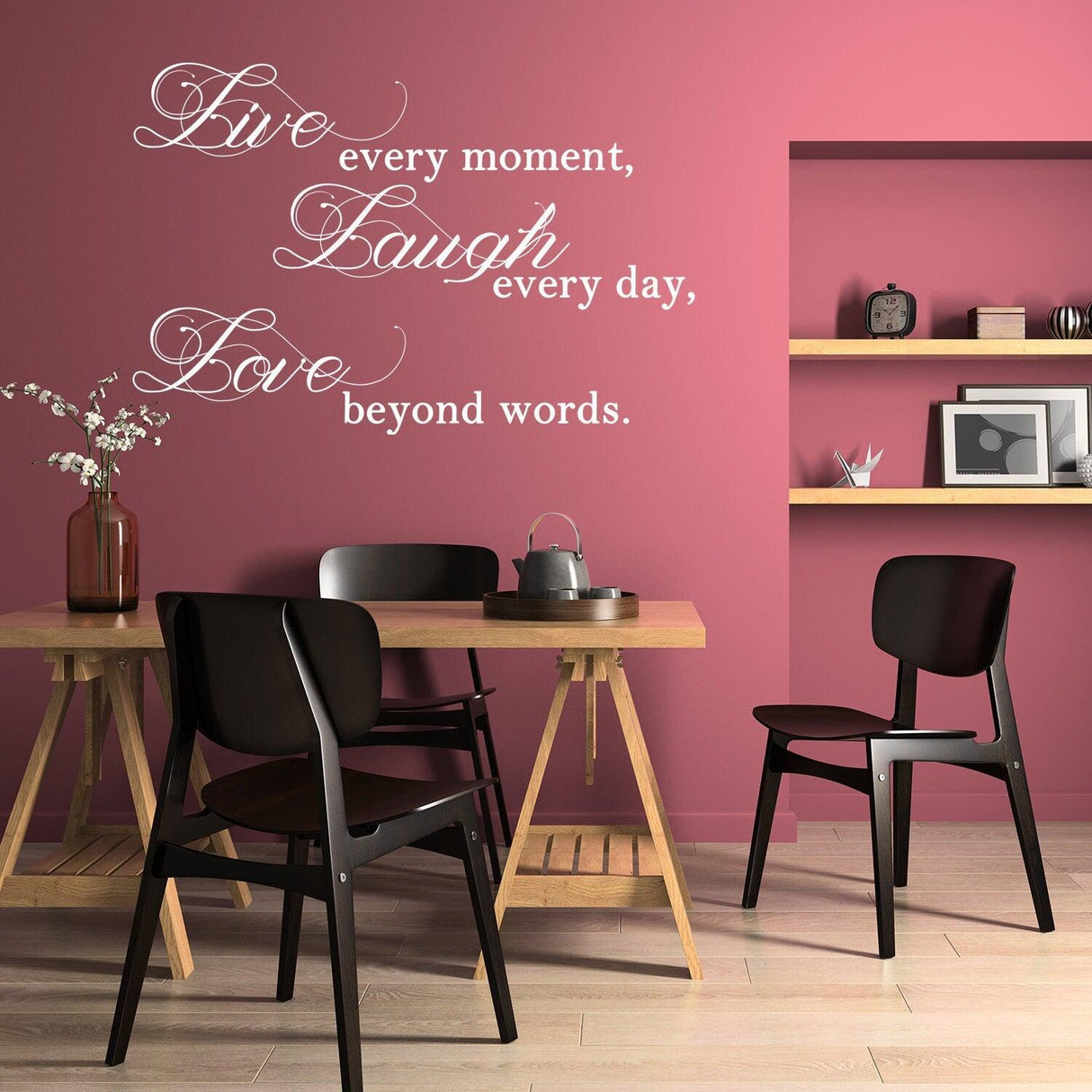 Live Laugh Love wall sticker in a stylish dining area with black chairs and pink walls for a positive decor.