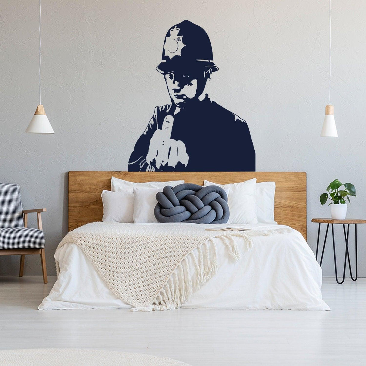 Banksy middle finger art wall decal of a policeman in a stylish bedroom setting.