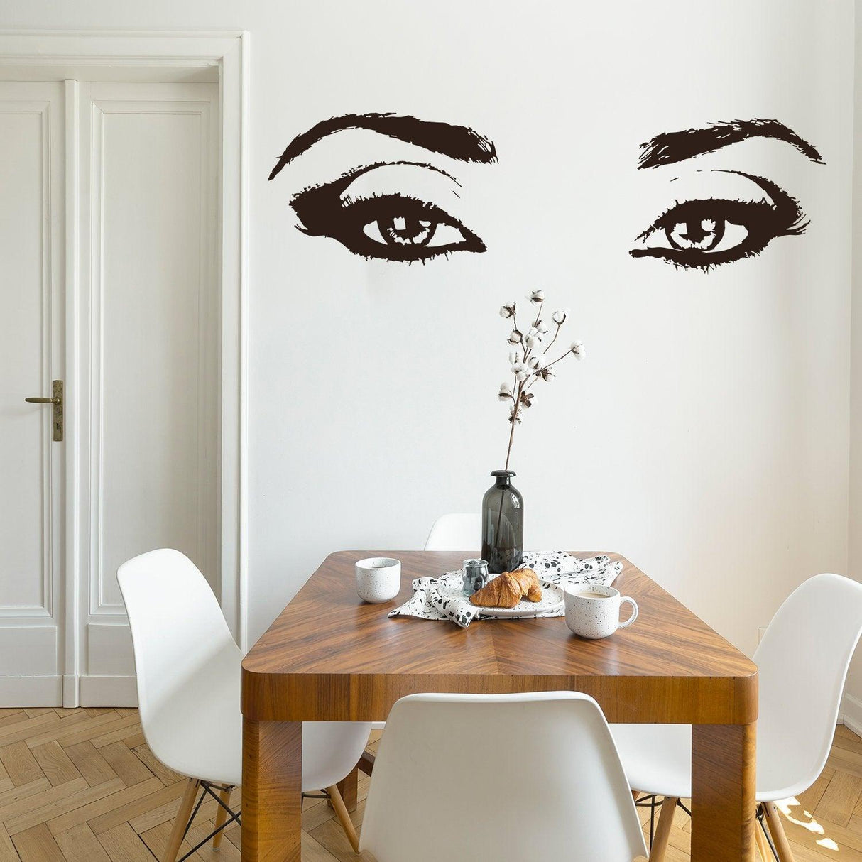 Elegant woman eye vinyl wall sticker above a dining table, enhancing beauty salon decor.