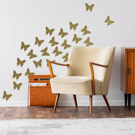 Decorative wall featuring butterfly stickers around a stylish armchair and wooden cabinet, creating a whimsical atmosphere.