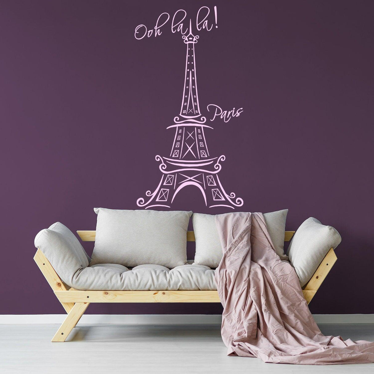 Eiffel Tower wall sticker in a modern living room with 'Oh la la!' text above a cozy sofa.