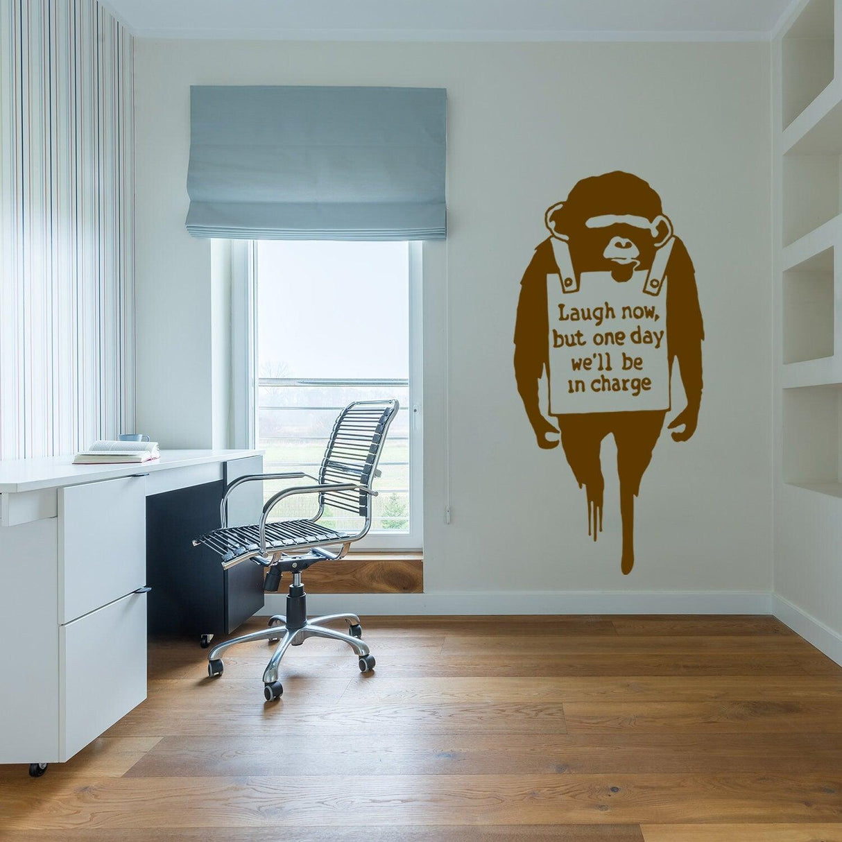 Banksy monkey wall sticker in a modern office, featuring the quote: 'Laugh now, but one day we'll be in charge'.