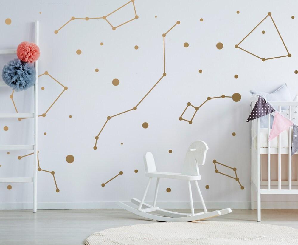 Gold constellation stickers on a white wall, adding a magical touch to a child's room with a rocking chair.